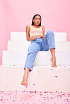 Woman, confetti and steps portrait with relax, style and fashion with celebration sparkle. Studio, pink background and female model with party, event and birthday decoration with gen z confidence