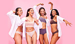 Fun, dancing and women friends in underwear in studio on pink background for beauty or skincare. Lingerie, health and wellness of female model group posing for diversity, body positive or inclusion
