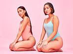 Diversity, underwear and portrait of women in studio, sitting together with glow and body positivity swimwear. Beauty, summer fashion and bikini models with self love, equality and pink background.