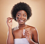 Smile, thinking and a black woman with mascara on a studio background for cosmetics and beauty. Happy, young an African girl or model with makeup idea for eyes, skincare and marketing on a backdrop