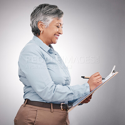 Buy stock photo Clipboard, writing and senior woman in a studio planning, brainstorming or working on a schedule. Happy, smile and elderly female model with a paper list and pen isolated by a gray background.