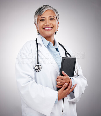 Buy stock photo Tablet, happy woman and portrait of doctor in studio for healthcare services, telehealth support and help. Mature medical worker, digital technology and planning hospital research on gray background