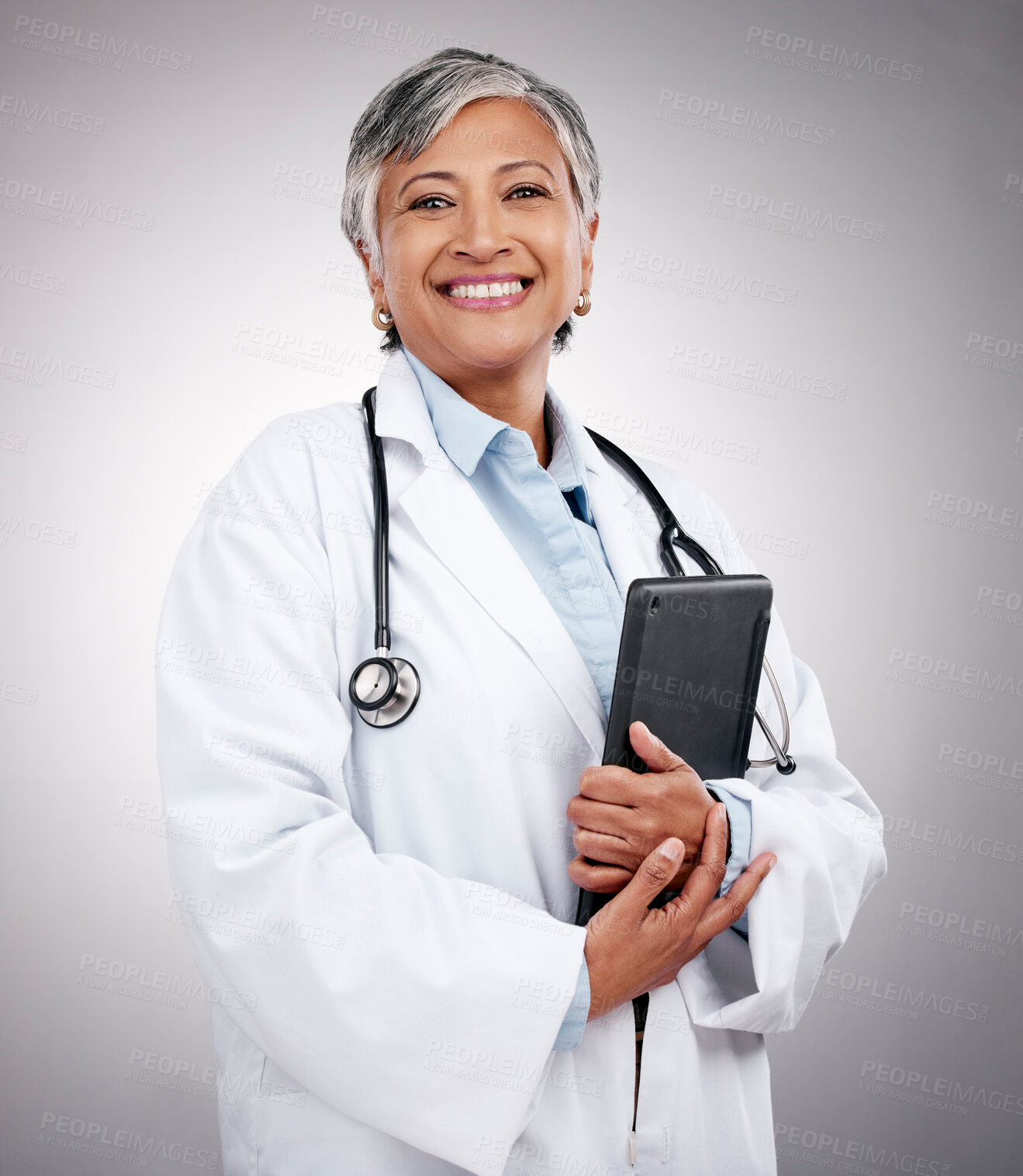 Buy stock photo Tablet, happy woman and portrait of doctor in studio for healthcare services, telehealth support and help. Mature medical worker, digital technology and planning hospital research on gray background