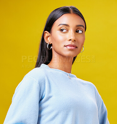 Buy stock photo Beauty, fashion and thinking with an indian woman on a yellow background in studio for trendy style. Mindset, idea and clothes with a young gen z model posing in clothes outfit for a magazine