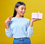 Woman, happy winner and gift box, presentation and prize, giveaway or shopping offer on yellow background. Excited person for present, ribbon package and retail sale, winning or competition in studio
