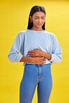 Sick, stomach pain and woman with constipation, digestion problem or diarrhea in studio isolated on a yellow background. Abdomen gas, disease and person with menstrual cramps, endometriosis or hernia