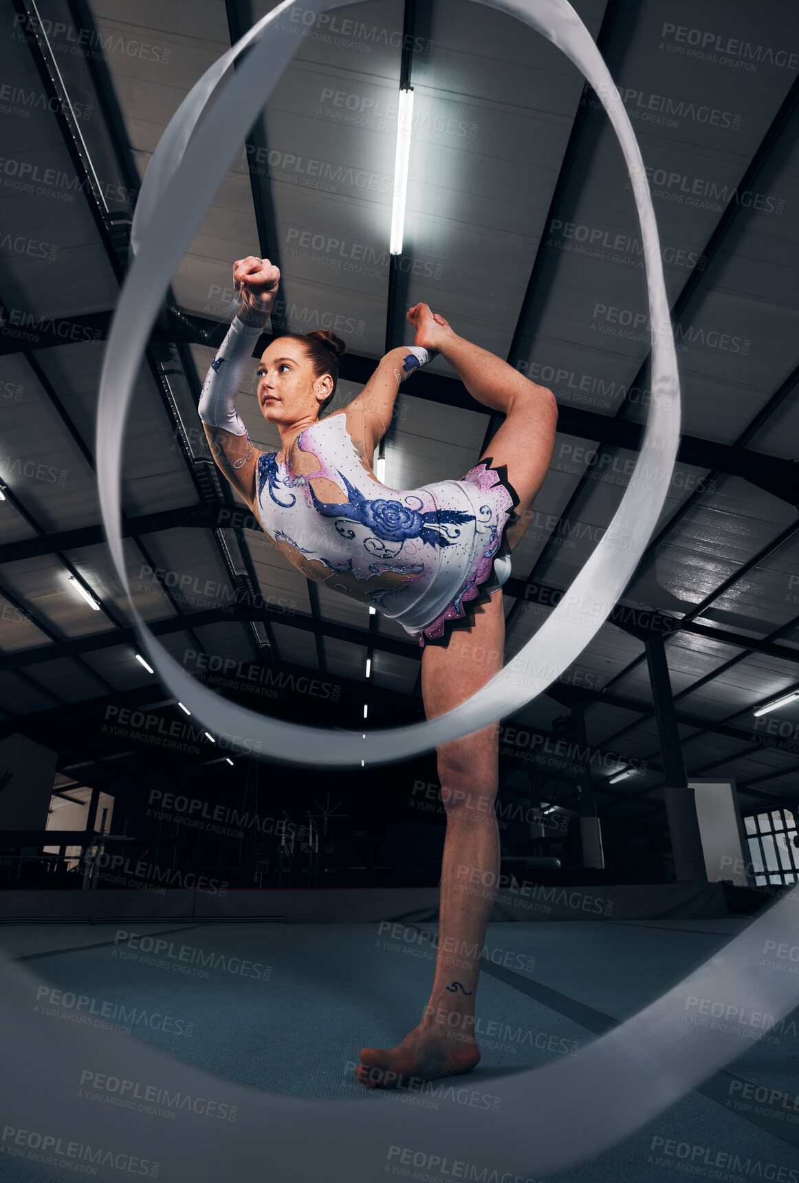 Buy stock photo Woman, dancer and balance for ribbon gymnastics in competition, sports performance or concert in dark arena. Flexible athlete, energy and stretching for agile training, challenge or rhythm in contest