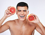 Beauty, grapefruit and natural with portrait of man in studio for health, detox or cosmetic. Vitamin c, nutrition and skincare with face of person and fruit on white background for self care and glow