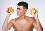 Beauty, orange and skincare with face of man in studio for health, detox and natural cosmetics. Vitamin c, nutrition and summer with person and fruit on white background for self care and glow 