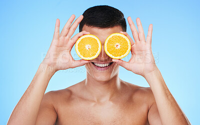 Buy stock photo Happy, lemon and skincare with face of man in studio for health, detox and natural cosmetics. Vitamin c, nutrition and summer with person and fruit on blue background for self care, beauty and glow 