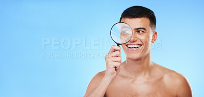 Buy stock photo Magnifying glass, skincare and man on blue background for wellness, healthy skin and mockup space. Dermatology, banner and face of person with lens for acne treatment, cosmetics and beauty in studio