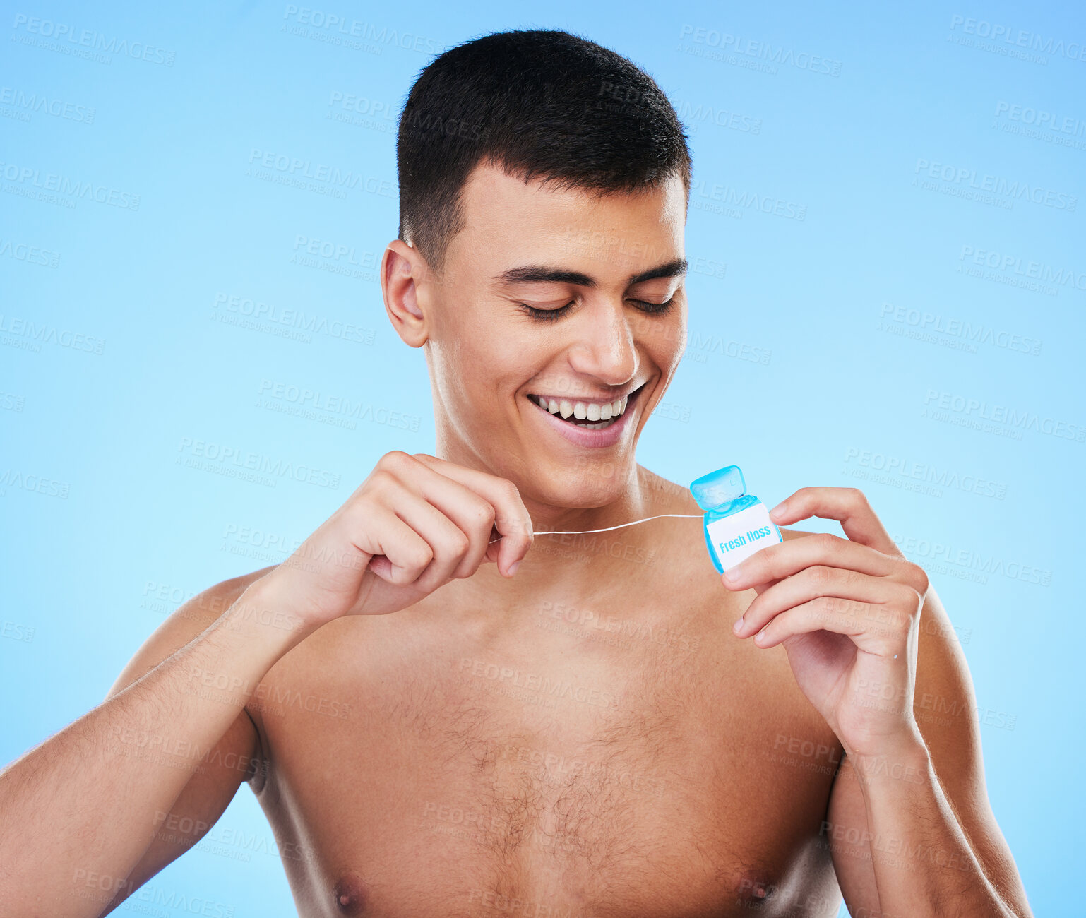 Buy stock photo Dental floss, man and teeth cleaning for healthcare, wellness and morning care in studio. Blue background, male model and happy from mouth hygiene with smile from healthy product for tooth protection