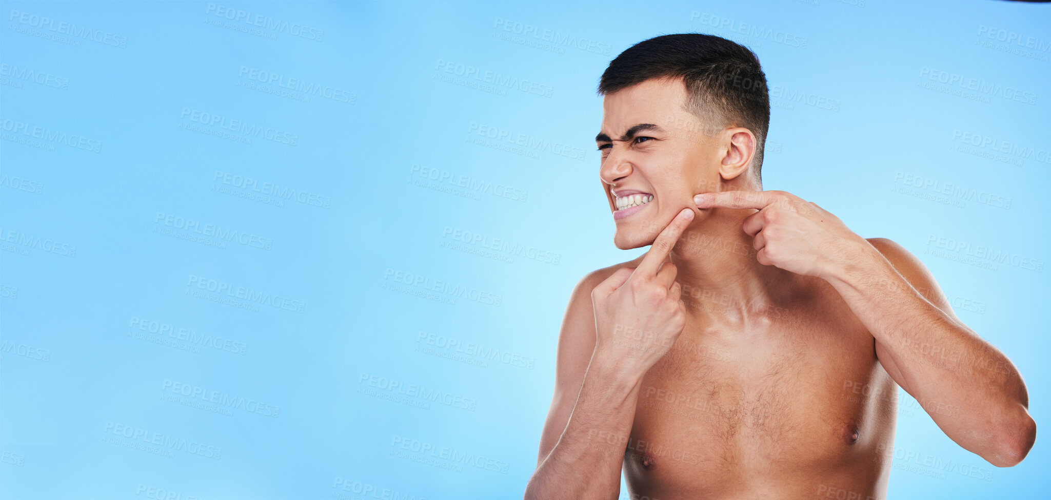 Buy stock photo Face, man and hands press pimple for acne or skin, mockup space and dermatology problem for skincare in studio on blue background. Self care, person scratch and pop blackhead for facial cleaning