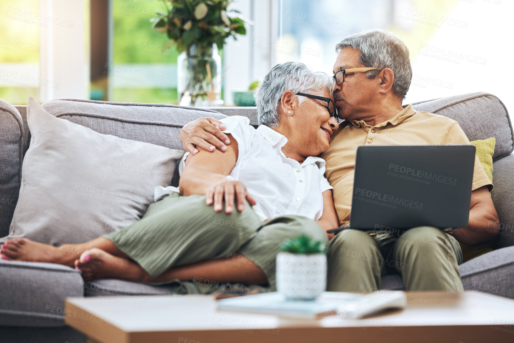 Buy stock photo Laptop, love and senior couple on sofa for watching movies, entertainment or streaming in living room. Retirement, marriage and happy man and woman kiss on computer for bonding, relax or film at home