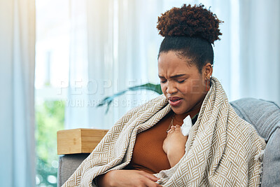 Buy stock photo Sick, tissue and chest infection with a black woman on a sofa in the living room of her home to relax. Asthma, allergy or coughing and a young person in a blanket for recovery from cold or flu