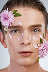 Natural, skincare and flowers with portrait of man in studio for spring, beauty cosmetics and creative. Glow, self love and floral with face of model on white background for makeup, spa and wellness