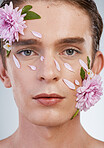 Spring, skincare and flowers with portrait of man in studio for beauty, natural cosmetics and creative. Glow, self love and floral with face of model on white background for makeup, spa and wellness