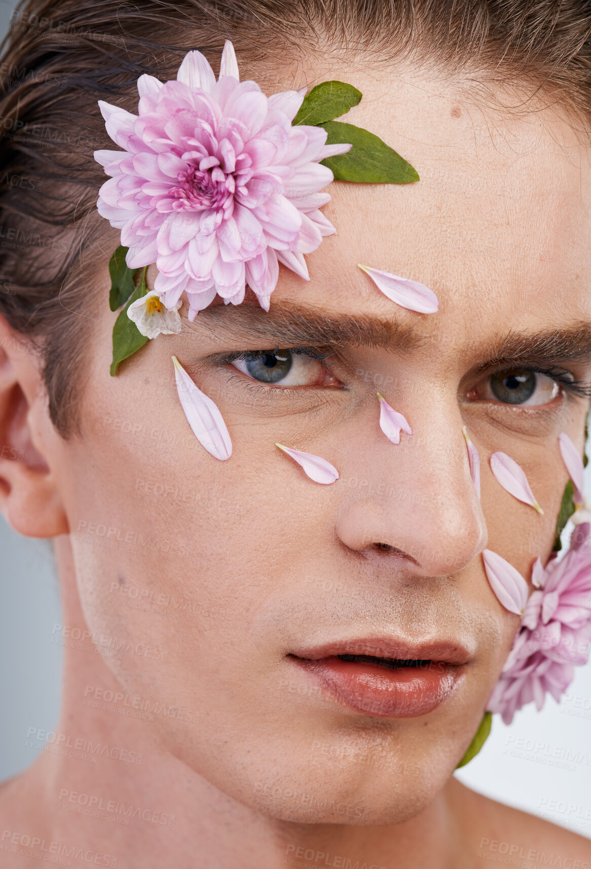 Buy stock photo Petals, skincare and flowers with portrait of man in studio for beauty, natural and creative. Glow, cosmetics and spring with face of model on white background for makeup, spa and floral wellness