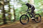 Woods, bicycle and man travel, blur and workout outdoor in forest for healthy body. Mountain bike, nature and athlete training, cycling fast or off road adventure on journey, freedom or fitness sport