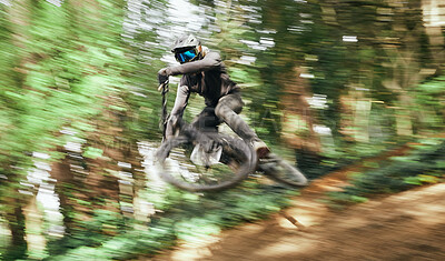 Buy stock photo Mountain bike, man and motion jump in forest for competition, challenge and off road adventure. Cycling athlete, sports and fast bicycle in air for action, performance race or power of speed in woods
