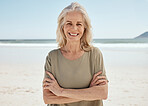 Beach portrait, arms crossed and senior woman relax for outdoor wellness, nature freedom or travel holiday in Canada. Sand, ocean sea water and elderly person smile for retirement vacation happiness