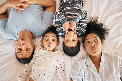 Buy stock photo Happy, funny face and portrait with family in bedroom for playful, morning and love. Care, support and wake up with parents and children from above in bed at home for weekend, positive or relax