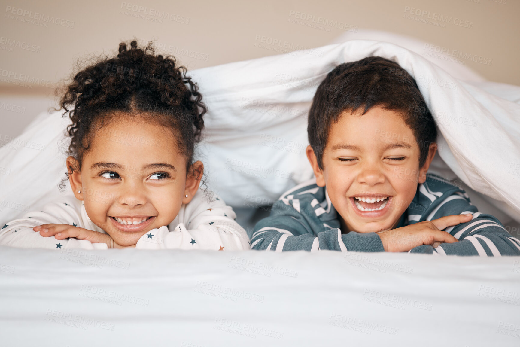 Buy stock photo Siblings, morning and face of children in bed in blanket for bonding, love and fun together at home. Family, childhood and happy young boy and girl smile in bedroom for relaxing, resting and laying