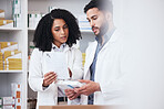 Healthcare, medicine and a pharmacist team with a box of prescription or chronic medication in a drugstore. Medical, pharmaceutical product and a medicine professional in a pharmacy with a colleague