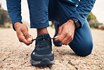 Tying laces, fitness and hands of a person for running, cardio or training preparation in nature. Closeup, ground and a runner or athlete with shoes and feet to start a race, marathon or a workout