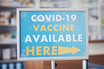 Covid 19 vaccine sign, arrow pointing and pharmacy announcement for virus protection, health safety or medical healthcare. Hospital clinic, billboard and poster notification for corona virus security