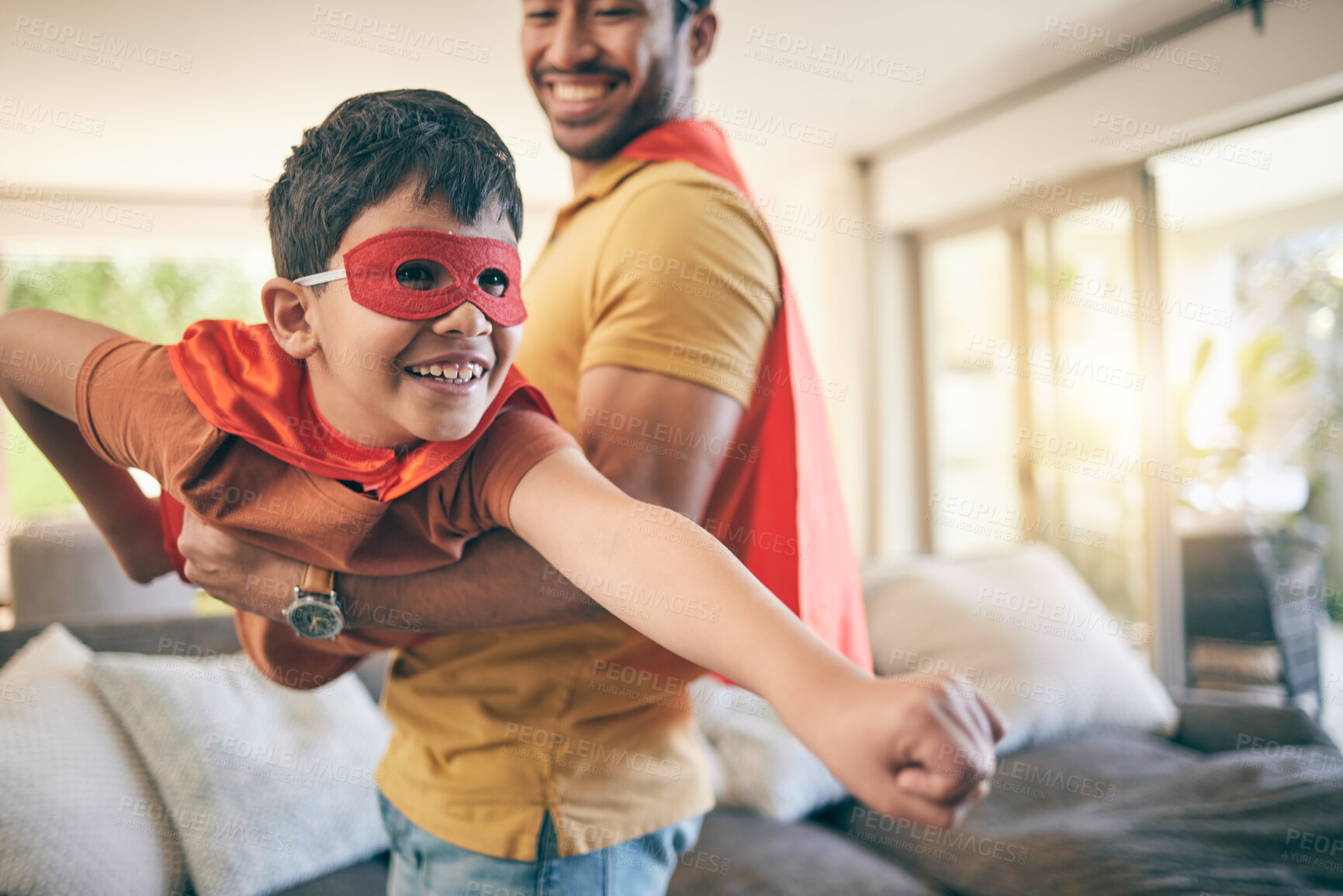 Buy stock photo Dad, boy and superhero game in living room, flying and power with smile, care and bonding in house. Father, young son and mask with comic laugh, playful and lift in air, lounge and family home