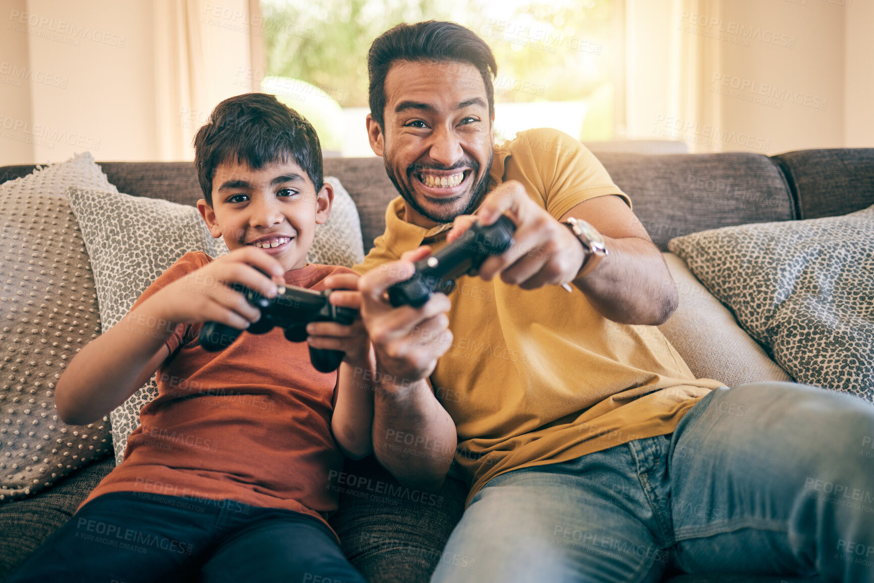 Buy stock photo Family, fun and a boy gaming with his father on a sofa in the living room of their home together for competition. Video game, children and a man learning how to play from his gamer son in the house