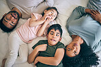 Top view, face and funny family in bed at home together, bonding to relax or having fun. Portrait, laughing and mother, father and children in bedroom, smile and happy for comedy in interracial house