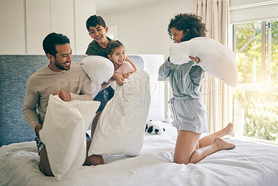 Buy stock photo Pillow fight, happy parents and family of kids play in bedroom with energy, funny games and joke together at home. Excited mother, father and children laughing with bed cushion for crazy morning 