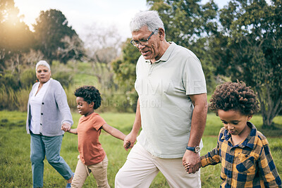 Buy stock photo Park, grandparents and children holding hands while walking as a family together in retirement. Senior man, woman and grandkids in a nature garden for bonding on summer holiday or vacation with flare