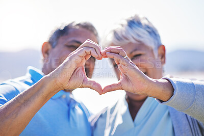 Buy stock photo Heart, hands and senior couple at a beach with love, care and trust while bonding in nature together. Emoji, finger and old people with thank you, support or sign of kindness, hope or freedom at sea