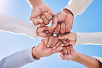 Hands in circle, blue sky and diversity for community in collaboration for global support and success. Teamwork, fist and bottom view of group of friends with positive vision, trust and love outdoors