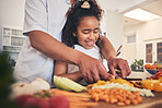 Cooking, vegetables and father with kid in the kitchen for child development, teaching and learning. Bonding, happy and dad helping girl to cut ingredients for a dinner, supper or lunch meal at home.