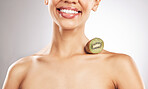 Skincare, kiwi and woman in studio smile for natural, beauty or treatment or eco friendly cosmetics on white background. Wellness, skin and female model with fruit for collagen, detox or vitamin C