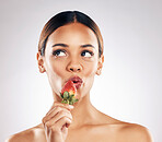 Skincare, kiss and woman with strawberry in studio for wellness, nutrition or natural cosmetics on white background. Beauty, face and female model with fruit for antioxidants or anti aging fine lines