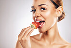 Woman, eating strawberry and skincare portrait, beauty or eco friendly product and natural cosmetics in studio. Happy person, face and red fruit for vegan makeup or dermatology on a white background