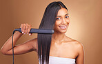 Straightener, hair care and woman portrait with smile and happy from Brazilian treatment in studio. Salon, natural beauty and hairdresser tool for healthy hairstyle and wellness with brown background