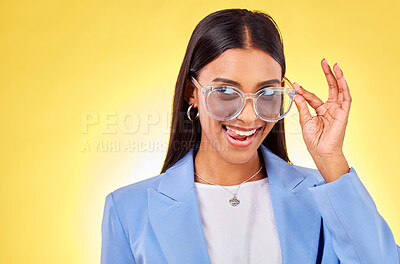 Buy stock photo Funny, woman and sunglasses with tongue out, comedy and silly face in a studio. Yellow background, crazy and young female person with modern fashion, trendy cool style and creative work clothing