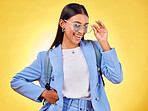 Fashion, student or portrait of woman in sunglasses on yellow background with trendy clothes or smile. Girl, happy person and excited gen z model with cool style, bag or elegant outfit in studio