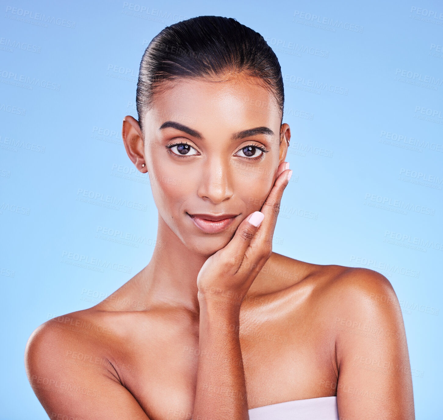 Buy stock photo Skincare, woman and hand on face in studio for wellness, cosmetic or treatment on blue background. Portrait, beauty and lady model touching glow, skin or smooth, dermatology or results satisfaction