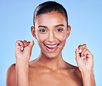 Woman, portrait and floss teeth in studio for healthy dental care, gum gingivitis and plaque on blue background. Happy indian model and oral thread for cleaning mouth, fresh breath and tooth hygiene 