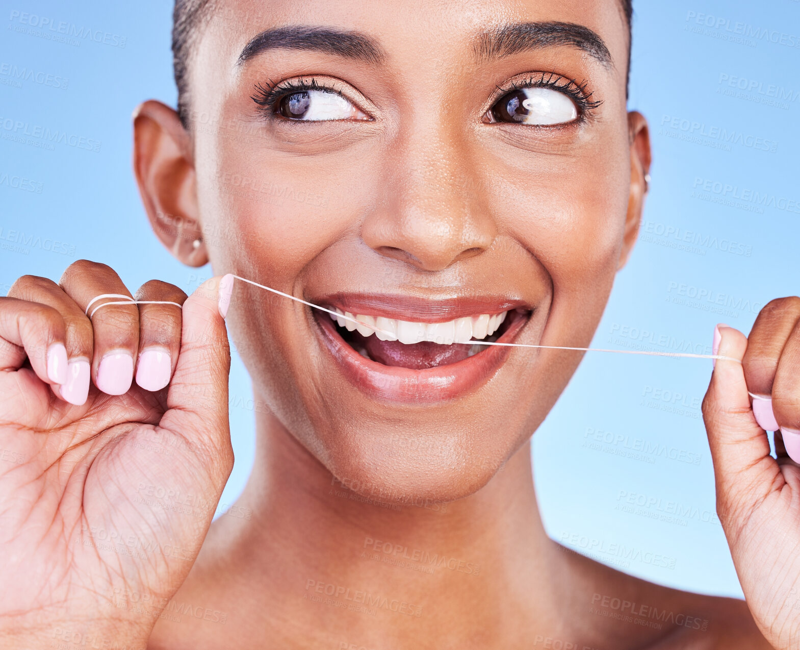 Buy stock photo Woman, smile and floss teeth in studio for healthy dental care, gum gingivitis or plaque on blue background. Face, happy indian model and oral thread for cleaning mouth, fresh breath or tooth hygiene