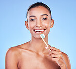 Portrait, happy woman and brushing teeth on blue background for dental wellness, care and healthy smile in studio. Indian model, bamboo toothbrush and cleaning mouth for oral hygiene of fresh breath 