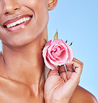 Woman with rose, closeup and natural beauty with sustainable skincare isolated on blue background. Wellness, skin glow and eco friendly cosmetics with pink flower, product and nature in a studio