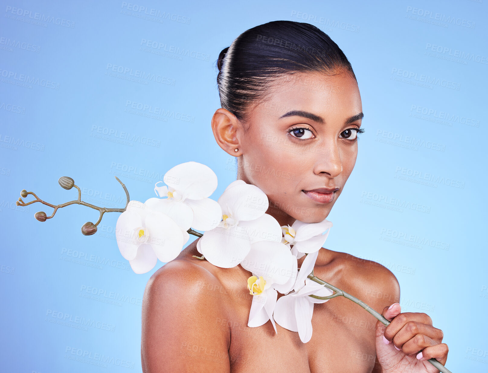 Buy stock photo Natural beauty, woman and face, flower and glow with wellness and eco friendly dermatology isolated on blue background. Sustainable skincare, orchid with collagen and cosmetics in portrait in studio